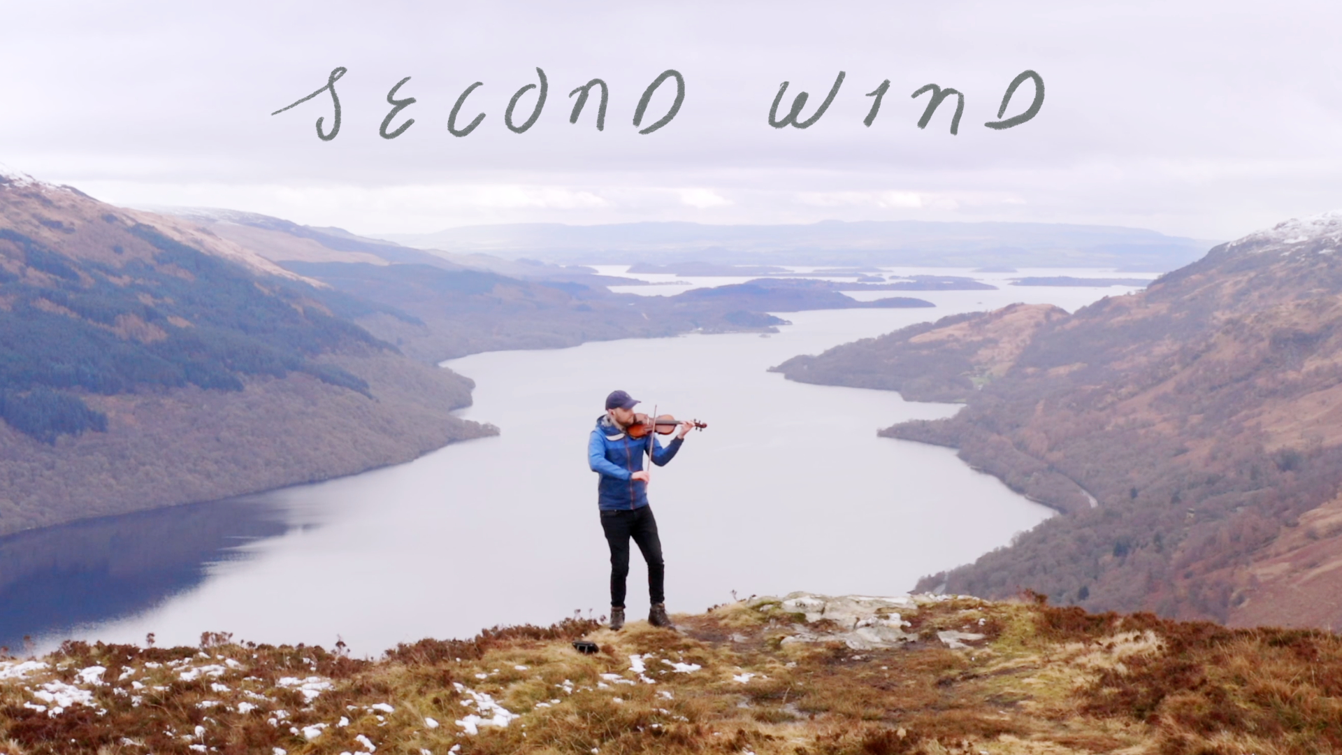 Cameron Mackay playing fiddle on top of a mountain in Loch Lomond, Scotland.